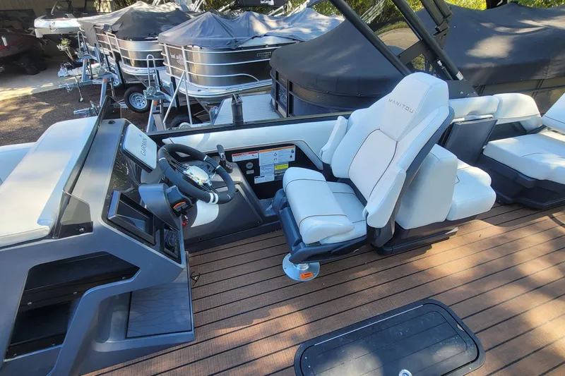 Slide: The Image of 2025 Manitou Explore 26 Switchback boat interior with modern helm and seating. - 5