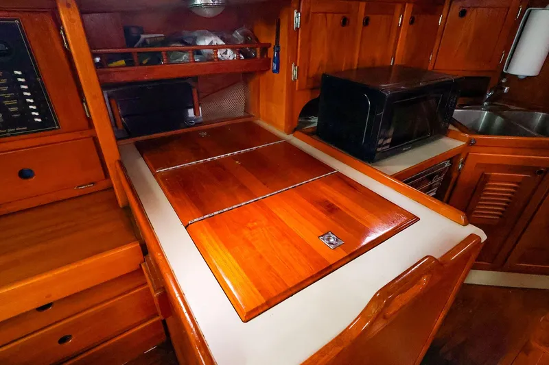 Slide: The Image of 1985 Bayfield 40 yacht galley with wooden cabinetry and modern appliances. - 19