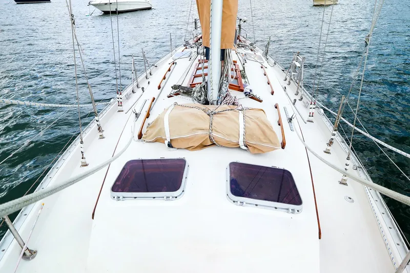 Slide: The Image of 1985 Bayfield 40 yacht deck with sails, moored on calm water. - 2