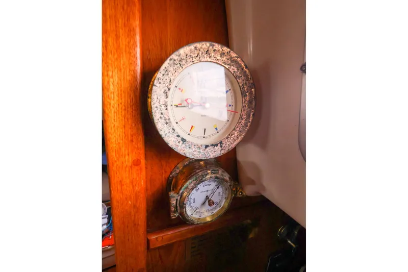 Slide: The Image of Vintage nautical instruments on 1985 Bayfield 40 yacht, featuring a clock and barometer. - 20
