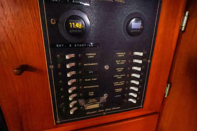 Slide: The Image of Electrical control panel on a 1985 Bayfield 40 yacht, featuring various switches and a voltmeter. - 21