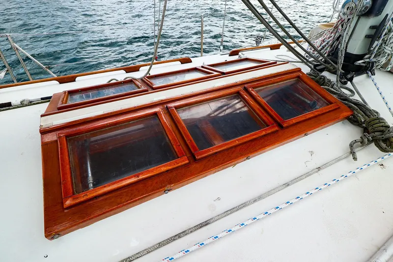 Slide: The Image of 1985 Bayfield 40 yacht deck with wooden hatches and rigging, sailing on water. - 7
