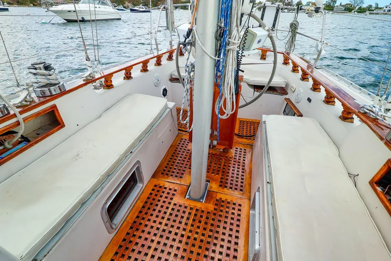 Slide: The Image of Cockpit of 1985 Bayfield 40 yacht with wooden accents and seating, docked on water. - 9