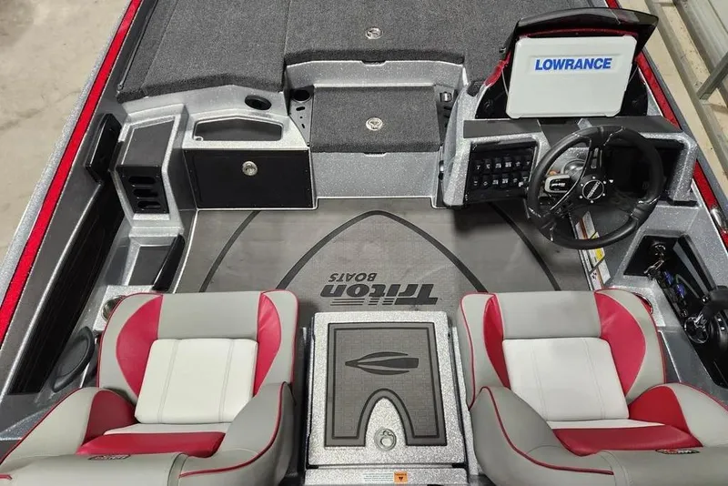 Slide: The Image of 2026 Triton 20XP Patriot boat interior with red and gray seats, steering wheel, and Lowrance display. - 2