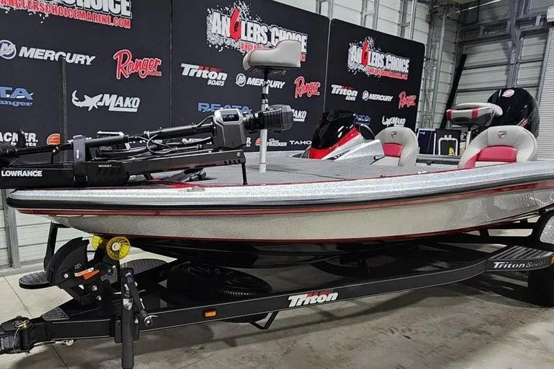 Slide: The Image of 2026 Triton 20XP Patriot boat on display in showroom with branded backdrop. - 3