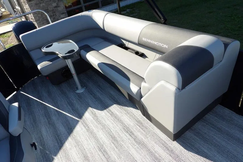 Slide: The Image of 2026 Bennington S L-Bench 22 SL boat interior with gray seating and table. - 13