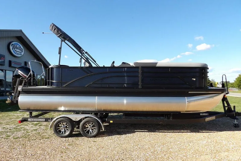 Slide: The Image of 2026 Bennington S L-Bench 22 SL pontoon boat on trailer, parked outdoors. - 2