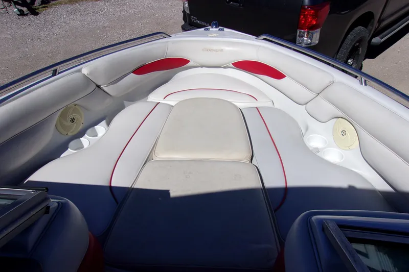 Slide: The Image of 2002 Crownline 202 BR boat interior with white and red seating, cup holders, and speakers. - 14