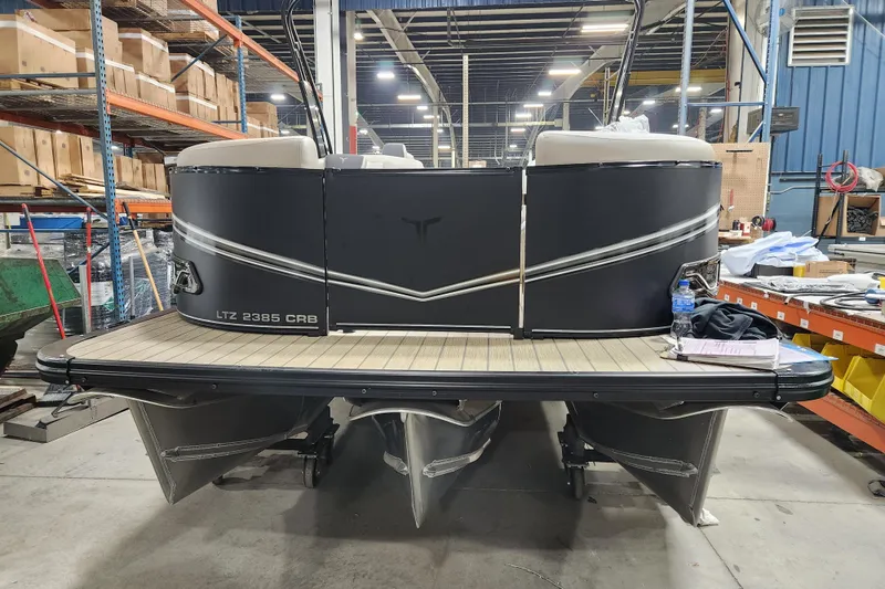 The Image of 2026 Avalon LSZ Cruise Rear Bench pontoon boat in a warehouse setting. - 1