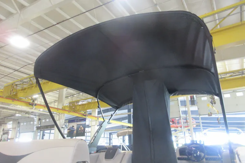 Slide: The Image of 2026 Avalon LSZ Cruise Rear Bench boat with canopy in a factory setting. - 17