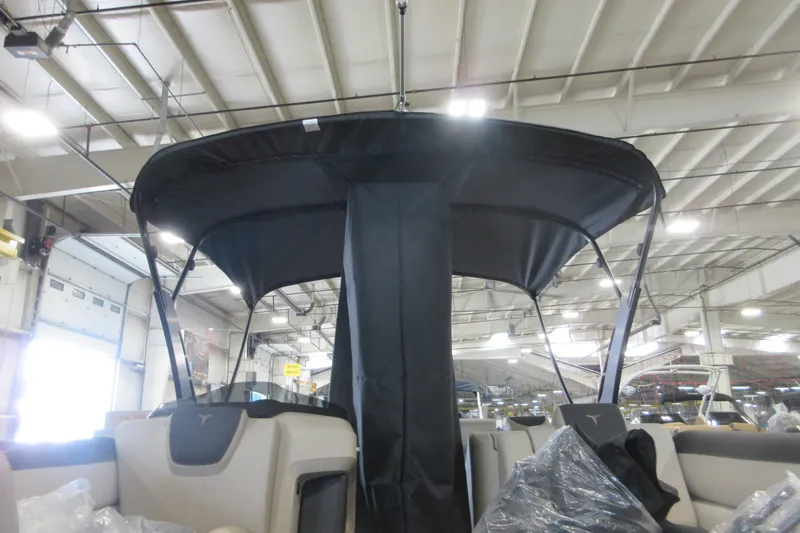 Slide: The Image of 2026 Avalon LSZ Cruise Rear Bench boat with canopy in a warehouse setting. - 19