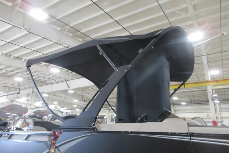 Slide: The Image of 2026 Avalon LSZ Cruise Rear Bench boat with canopy in a showroom. - 20