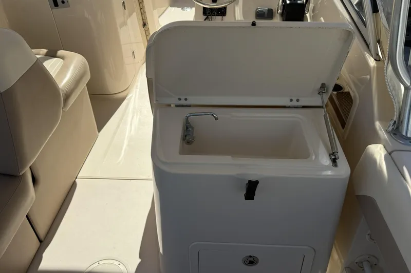 Slide: The Image of 2014 Grady-White Freedom 275 boat interior with sink and seating area. - 28
