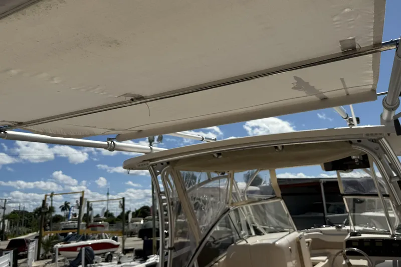 Slide: The Image of 2014 Grady-White Freedom 275 boat with canopy, clear sky background. - 32