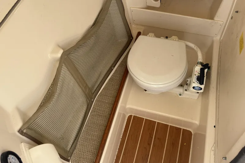 Slide: The Image of 2014 Grady-White Freedom 275 boat toilet with wooden flooring and storage net. - 40