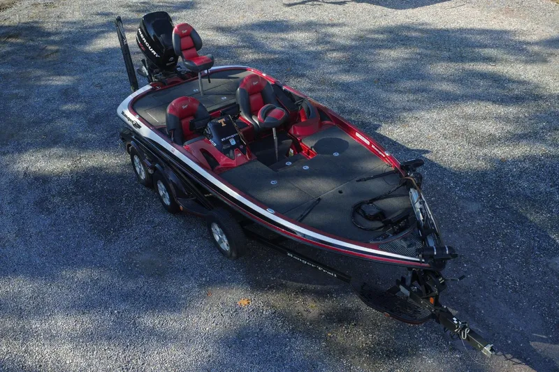 The Image of 2011 Ranger Z119 bass boat with red and black design on a gravel surface. - 0