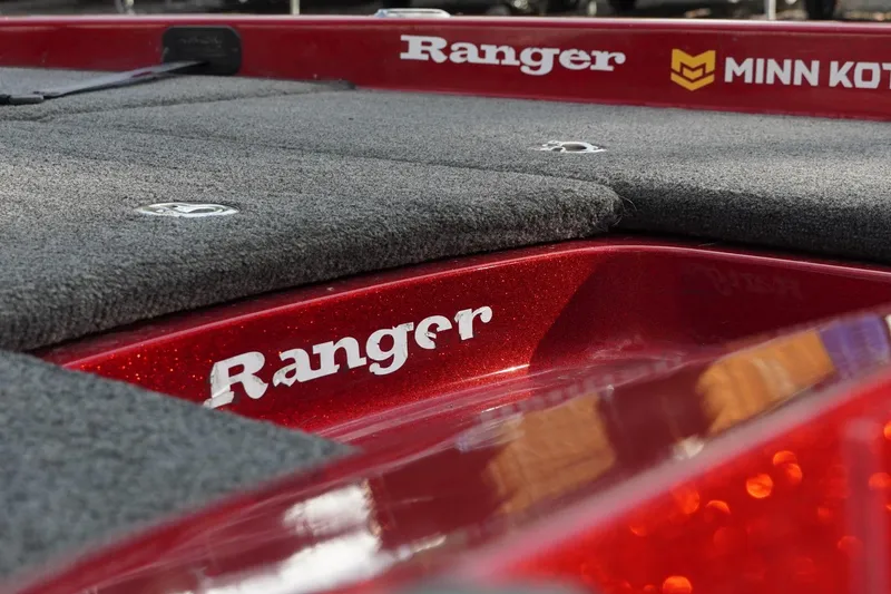 Slide: The Image of 2011 Ranger Z119 boat deck with Minn Kota logo, red finish, and carpeted surface. - 10