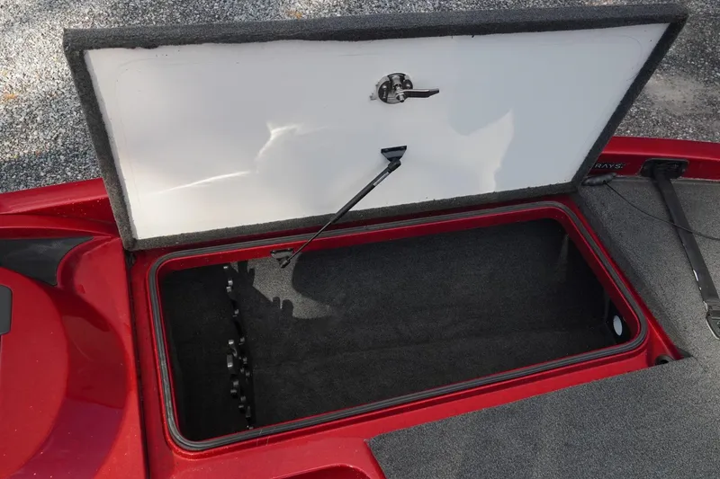 Slide: The Image of Open storage compartment in 2011 Ranger Z119 boat, featuring red and gray interior. - 13
