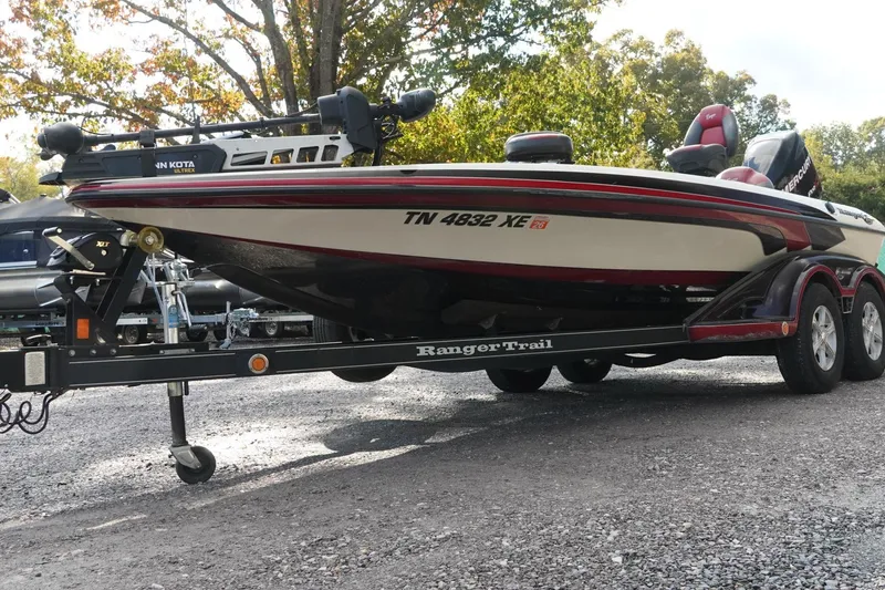 Slide: The Image of 2011 Ranger Z119 boat on trailer, parked outdoors, with visible registration number. - 3