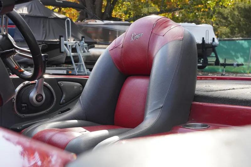 Slide: The Image of 2011 Ranger Z119 boat seat with red and black upholstery, steering wheel visible. - 8