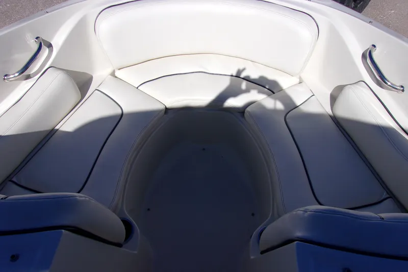 Slide: The Image of Interior seating of a 2007 Sea Ray 210 Select boat, featuring white cushioned seats. - 12