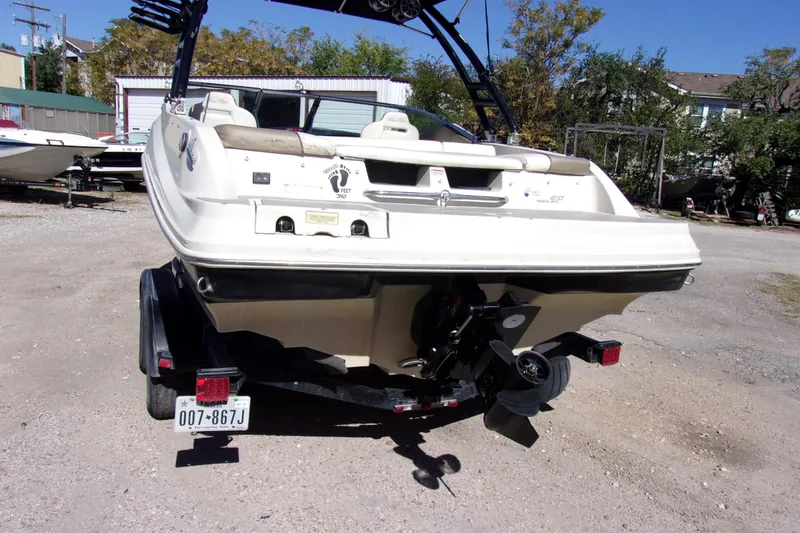 Slide: The Image of Rear view of a 2007 Sea Ray 210 Select boat on a trailer in a yard. - 3