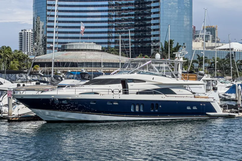 Slide: The Image of Luxury Fairline 74 Custom yacht, 2006 model, docked in a marina with cityscape backdrop. - 1