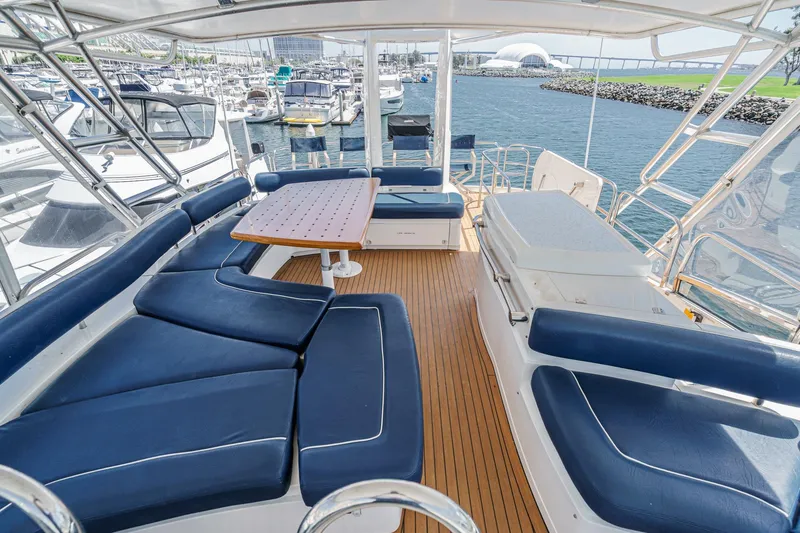 Slide: The Image of Luxurious 2006 Fairline 74 Custom yacht deck with blue seating and wooden flooring. - 10