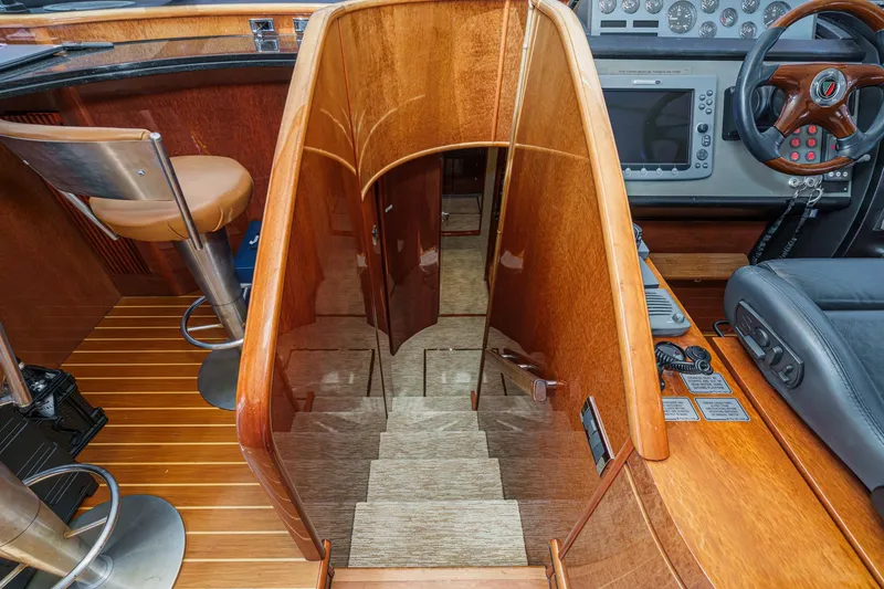 Slide: The Image of Interior of 2006 Fairline 74 Custom yacht, featuring wooden stairs and modern helm controls. - 26