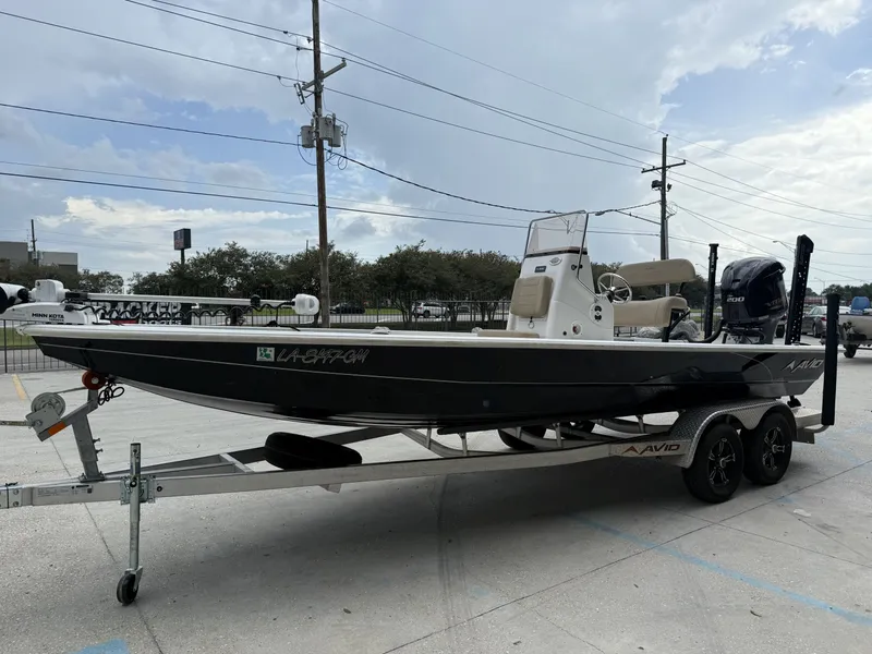 Slide: The Image of 2020 Avid 23 FS boat on trailer, parked outdoors under cloudy sky. - 4