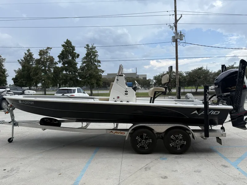 Slide: The Image of 2020 Avid 23 FS boat on trailer with Yamaha engine, parked outdoors. - 5