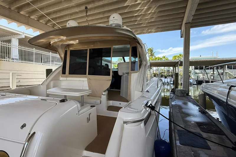 Slide: The Image of 2011 Tiara Yachts 4500 Sovran docked under a covered marina. - 18