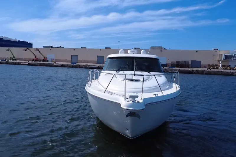 Slide: The Image of 2011 Tiara Yachts 4500 Sovran in marina, clear sky, industrial background. - 2