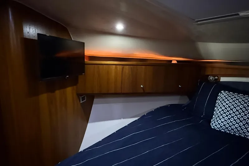 Slide: The Image of Luxurious cabin interior of 2011 Tiara Yachts 4500 Sovran with wood paneling and cozy bedding. - 50