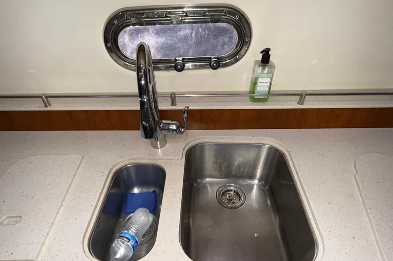 Slide: The Image of Kitchen sink area on a 2011 Tiara Yachts 4500 Sovran with porthole and soap dispenser. - 64