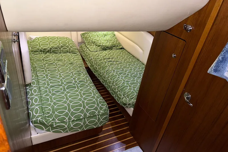Slide: The Image of 2011 Tiara Yachts 4500 Sovran cabin with twin beds and green patterned bedding. - 75