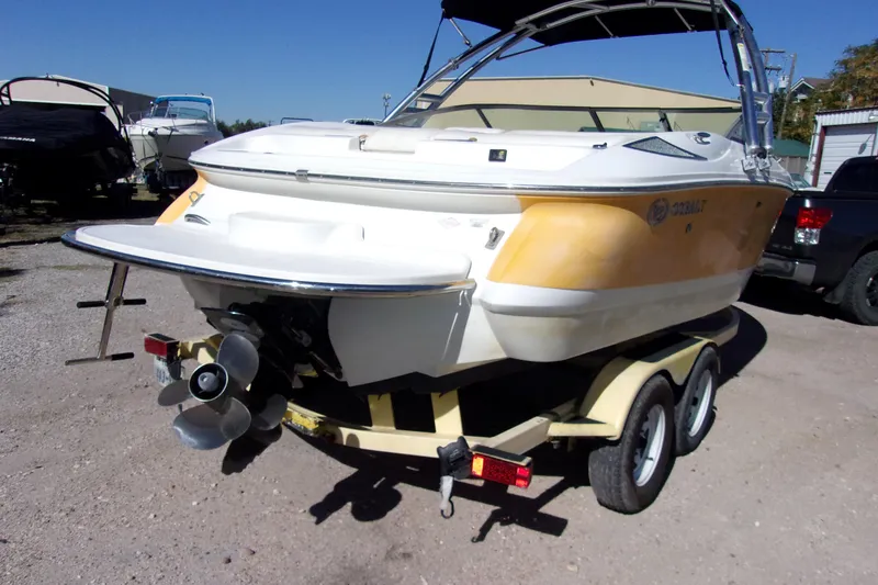 Slide: The Image of 2005 Cobalt 200 boat on trailer, yellow and white, parked outdoors. - 4