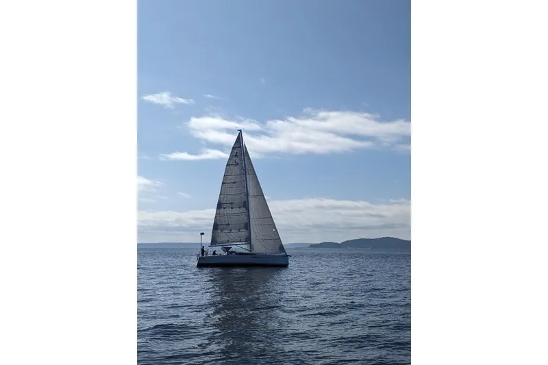 Slide: The Image of 2021 J Boats J/112E sailing on calm waters under a clear blue sky. - 13