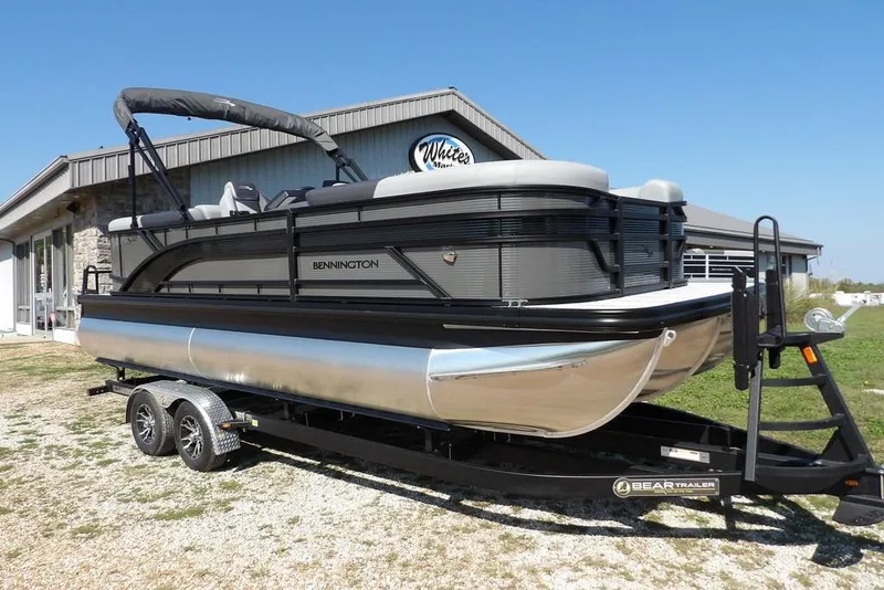 The Image of 2026 Bennington S Quad Bench 22 SSR pontoon boat on trailer, parked outside a building. - 1
