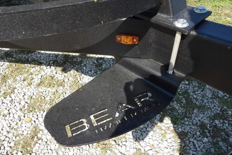 Slide: The Image of Trailer hitch detail of 2026 Bennington S Quad Bench 22 SSR on gravel. - 40