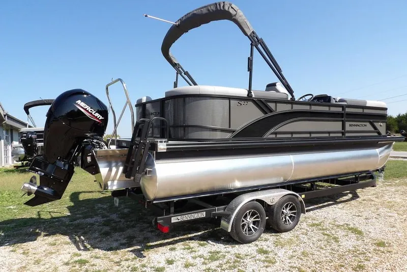 Slide: The Image of 2026 Bennington S Quad Bench 22 SSR pontoon boat on trailer, featuring Mercury outboard motor. - 8
