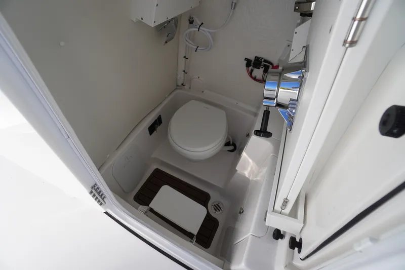 Slide: The Image of 2026 Tidewater 256 CC Adventure boat interior with open cabin door and steering console. - 24