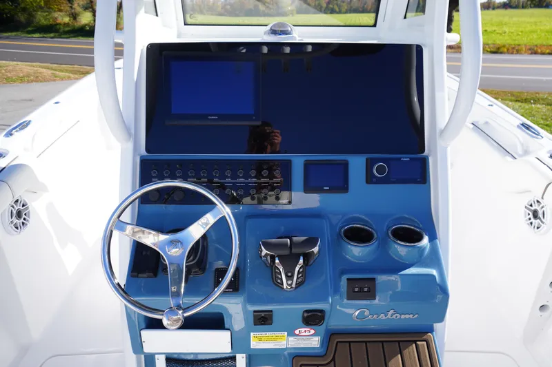 Slide: The Image of 2026 Tidewater 256 CC Adventure boat cockpit with steering wheel and control panel. - 28