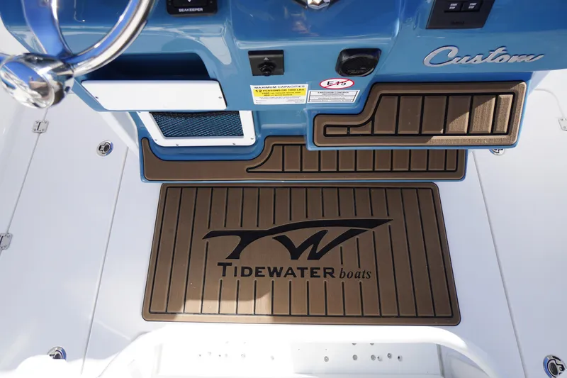 Slide: The Image of 2026 Tidewater 256 CC Adventure boat dashboard with custom blue finish and controls. - 31