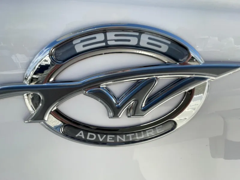 Slide: The Image of 2026 Tidewater 256 CC Adventure boat with Yamaha engine, ladder, and blue hull on blocks. - 4