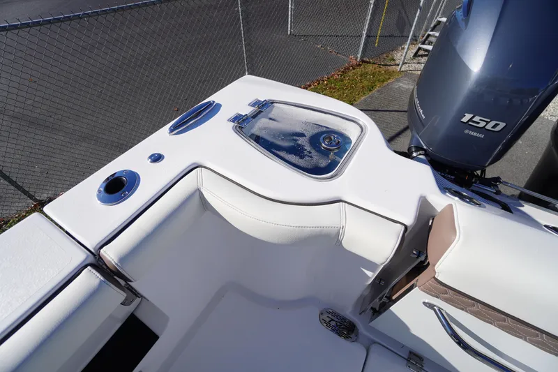 Slide: The Image of 2026 Tidewater 256 CC Adventure boat interior with white deck and storage compartments. - 57