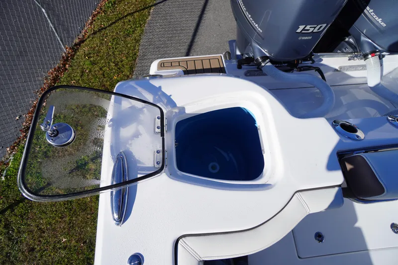 Slide: The Image of 2026 Tidewater 256 CC Adventure boat interior with white seating and storage compartments. - 58