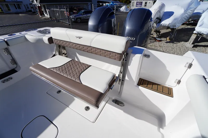 Slide: The Image of 2026 Tidewater 256 CC Adventure boat interior, featuring sleek white seating and storage compartments. - 61
