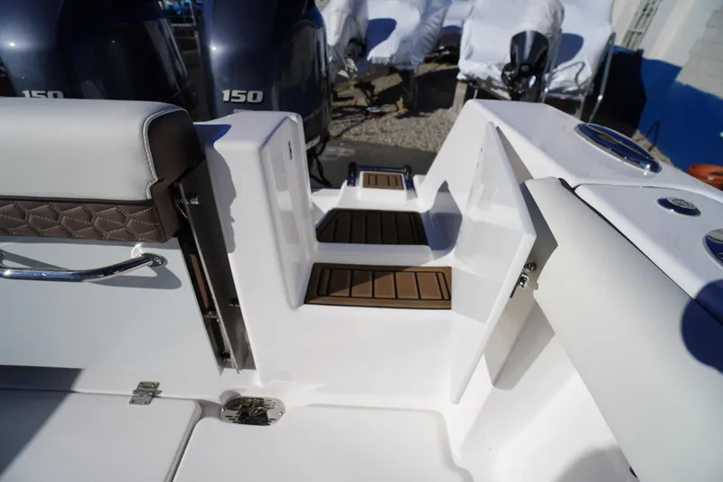 Slide: The Image of 2026 Tidewater 256 CC Adventure boat with dual Yamaha 150 engines, docked outdoors. - 65