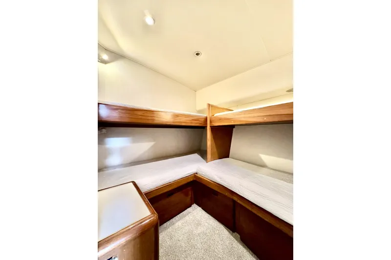 Slide: The Image of 1999 Viking 43 Convertible yacht interior with cozy bunk beds and wooden accents. - 10